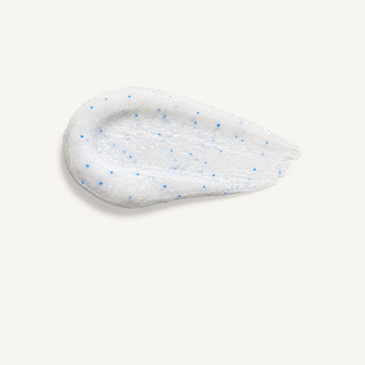White ZO Dual Action Scrub texture with blue beads on cream background
