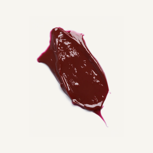 Facile Lip Jelly Berry glossy wine-red texture swatch on Minte’s warm cream background