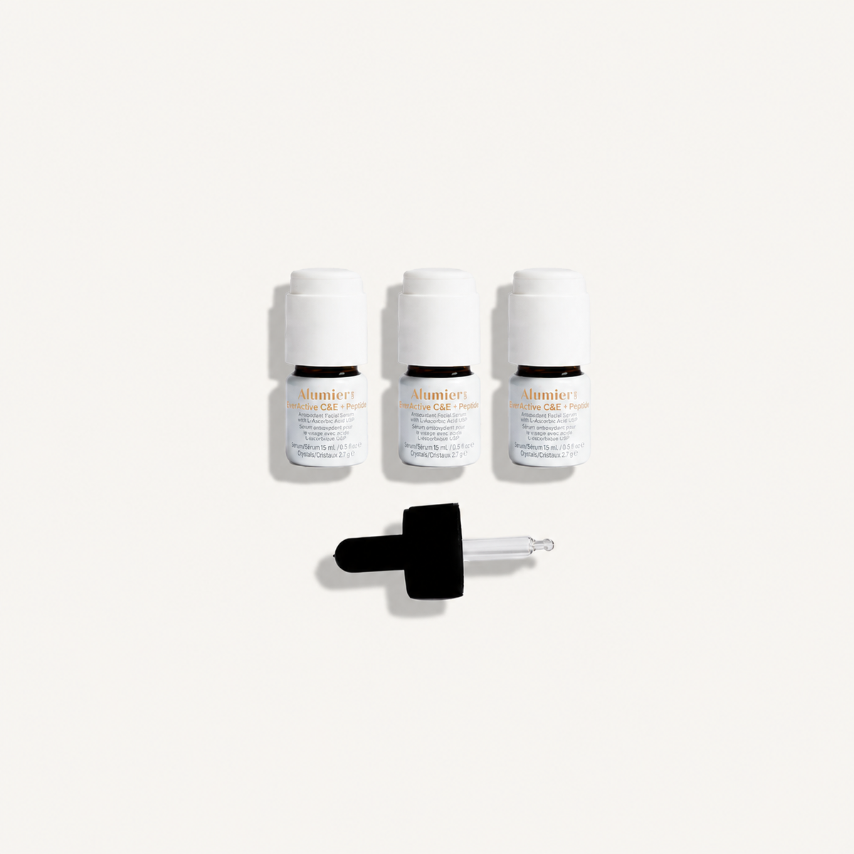 AlumierMD EverActive C&E + Peptide three-pack with dropper on a warm ivory background
